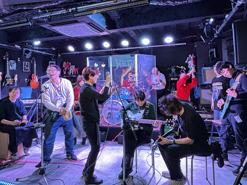 ステージで大勢で演奏を楽しむ一団