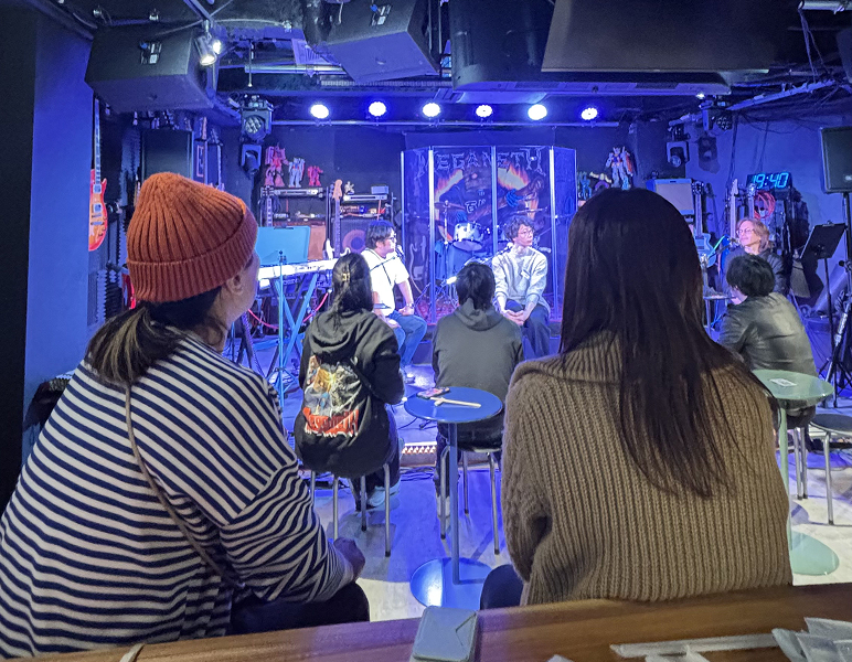 ライブハウス後方からステージを見守る女性二人